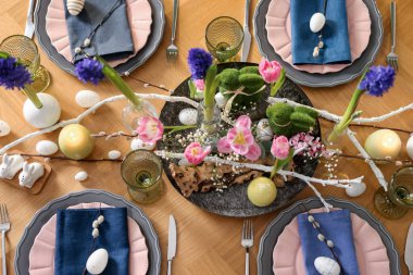 Paskalya kutlaması. Çiçekli şenlik masası ve kapalı alanda yumurtalar, düzlük.