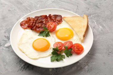 Yağda yumurta ve pastırma ile nefis bir kahvaltı. Dokuma masasında servis ediliyor. Yakın plan.