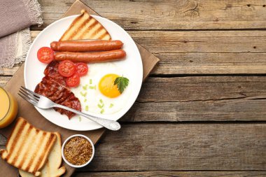 Tahta masada servis edilen sahanda yumurta, sosis ve domuz pastırması ile nefis bir kahvaltı. Metin için boşluk