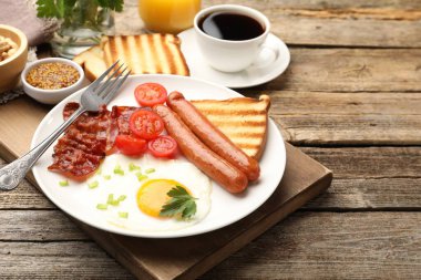 Tahta masada kızarmış yumurta, sosis ve domuz pastırması ile nefis bir kahvaltı.