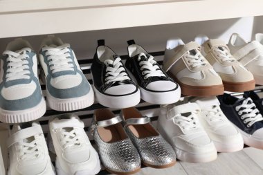 Ayakkabı dolabında farklı çocuk ayakkabıları var.