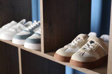 İçerideki ahşap raflarda farklı stil çocuk ayakkabıları, yakın plan.