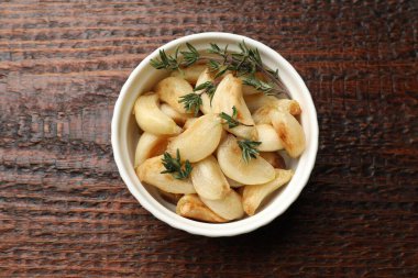 Ahşap masada kekik desenli ızgara sarımsak.