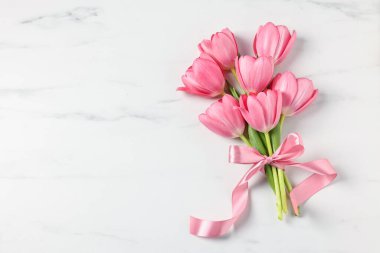 Beyaz mermer masa üzerinde pembe laleler, üst manzara. Metin için boşluk