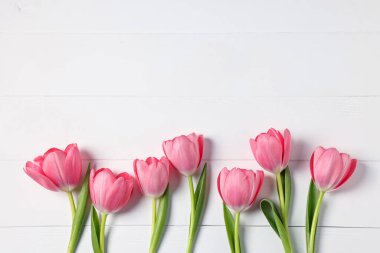 Beyaz ahşap masadaki güzel pembe laleler, düz yatıyordu. Metin için boşluk