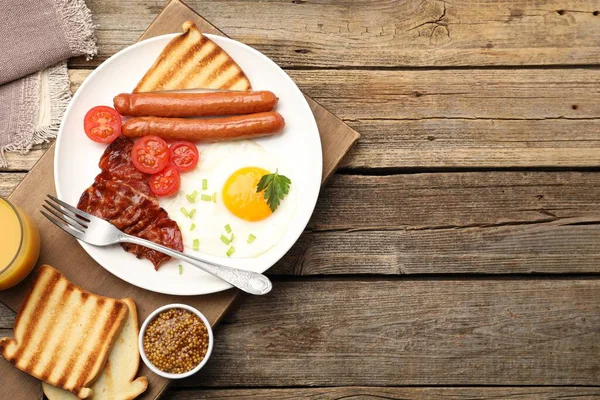 Tahta masada servis edilen sahanda yumurta, sosis ve domuz pastırması ile nefis bir kahvaltı. Metin için boşluk