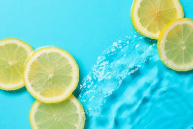 Açık mavi arka planda limon dilimleri, düz. Metin için boşluk