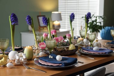 Paskalya kutlaması. Çiçeklerle süslü masa ve kapalı alanda yumurtalar.