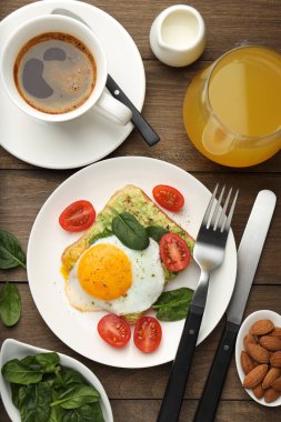 Tahta masada servis edilen avokado tostlu sağlıklı bir kahvaltı.