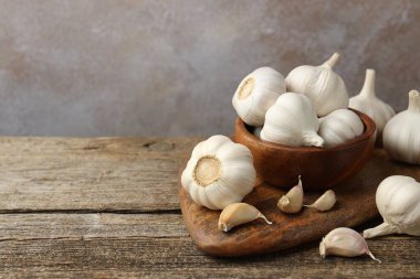 Taze sarımsak soğanları ve karanfiller ahşap masada, yakın plan. Metin için boşluk