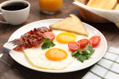 Yağda yumurta ve pastırma ile nefis bir kahvaltı, ahşap masada servis edilir, yakın plan.