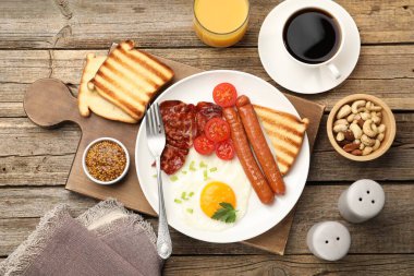 Tahta masada servis edilen kızarmış yumurta, sosis ve domuz pastırması ile nefis bir kahvaltı.