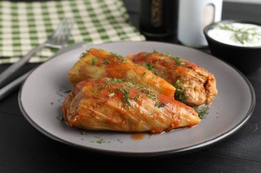 Siyah masada servis edilen lezzetli lahana dürümleri.