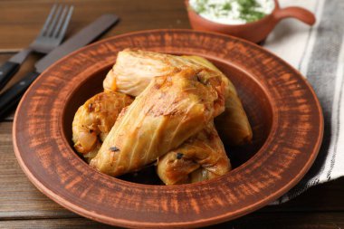 Tahta masada servis edilen lezzetli lahana dürümleri, yakın plan.