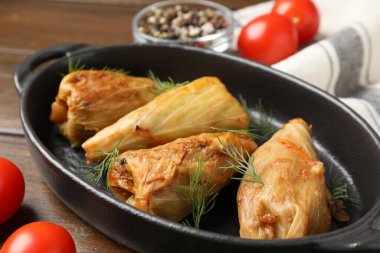 Tahta masada servis edilen lezzetli lahana dürümleri, yakın plan.