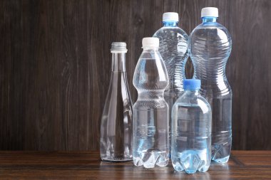 Ahşap masada farklı boyutlarda su şişeleri, metin için yer