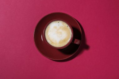 Kırmızı arka planda bir fincan aromatik kahve.