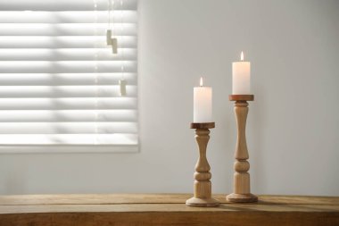 İçerideki ahşap masada yanan mumları olan zarif şamdanlar, metin için yer.