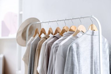 Farklı tarz kıyafetler ve askıda asılı duran şapkalar, yakın plan.