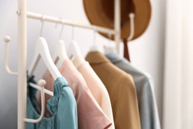 Farklı tarz kıyafetler ve askıda asılı duran şapkalar, yakın plan.