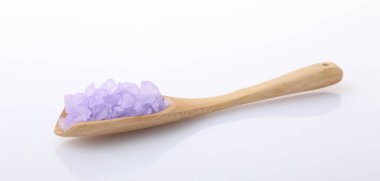 Tahta kaşıkta mor deniz tuzu. Beyaz kaşıkta izole edilmiş.