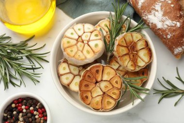 Biberiyeli ızgara sarımsak, biber, ekmek ve yağ beyaz masada, düz yerde.