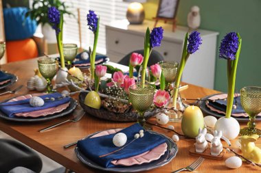 Paskalya kutlaması. Çiçeklerle süslü masa ve kapalı alanda yumurtalar.