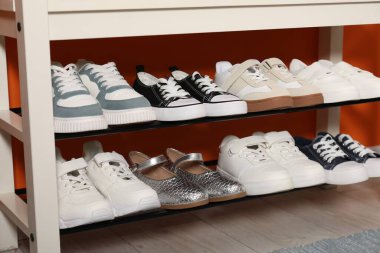 İçerideki raflarda farklı stil çocuk ayakkabıları, yakın plan.