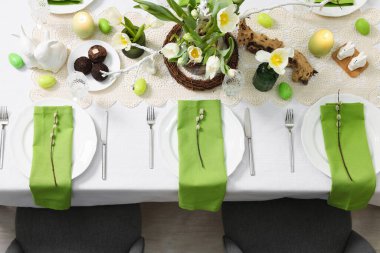 Paskalya kutlaması. Zarif bulaşık takımları ve çiçekli şenlik masası, üst görünüm