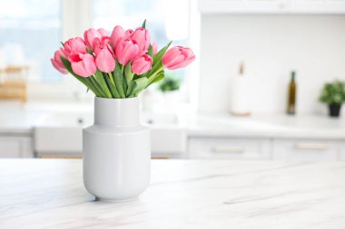 Beyaz mermer masadaki vazodaki güzel pembe laleler, metin için yer.