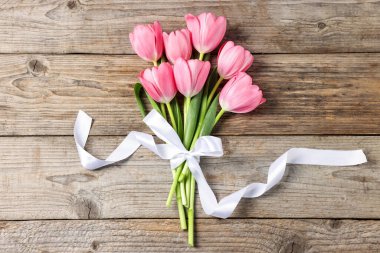 Ahşap masada pembe laleler, üst manzara.