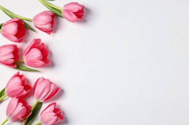 Beyaz masadaki güzel pembe laleler, düz uzanmış. Metin için boşluk