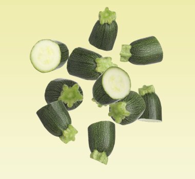 Kabak parçaları sarı arkaplana doğru düşüyor. Taze sebze.