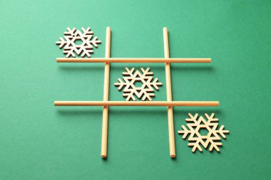 Yeşil zemin üzerinde tahta kar taneleriyle yapılan tik tak parmak oyunu