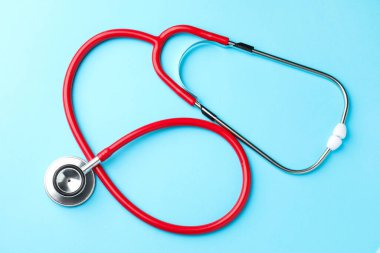 Açık mavi arkaplanda kırmızı steteskop, üst görünüm
