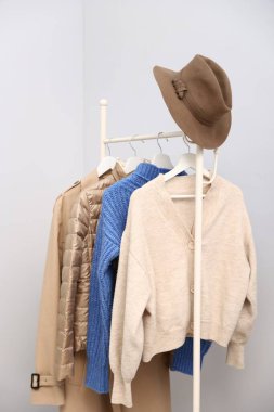 Farklı tarz kıyafetler ve askıda asılı duran şapkalar.