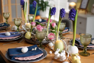 Paskalya kutlaması. Çiçekli şenlik masası ve kapalı mekanda yumurtalar, yakın plan.