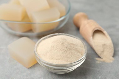 Jelatin tozu ve jöle küpleri gri masada, yakın plan.