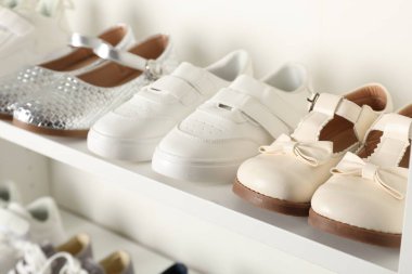 İçerideki raflarda farklı tarz çocuk ayakkabıları, yakın plan.