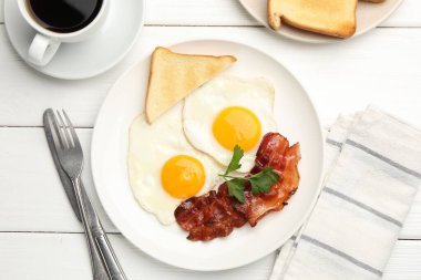 Beyaz ahşap masada servis edilen omlet ve pastırmayla nefis bir kahvaltı.