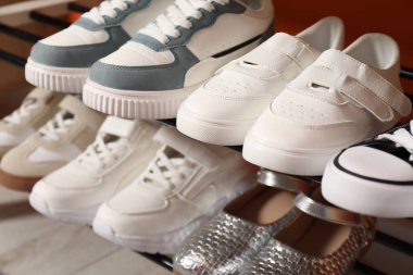 İçerideki raflarda farklı stil çocuk ayakkabıları, yakın plan.