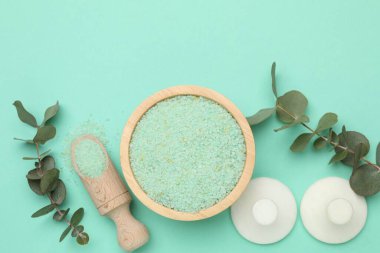 Kasede yeşil deniz tuzu, kepçe, masaj taşları ve turkuaz arka planda okaliptüs dalları.