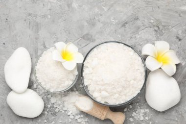 Kaselerdeki deniz tuzu, kepçeler, tesisat çiçekleri ve gri masadaki spa taşları, düz yatıyordu.