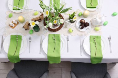 Paskalya kutlaması. Zarif bulaşık takımları ve çiçekli şenlik masası, üst görünüm