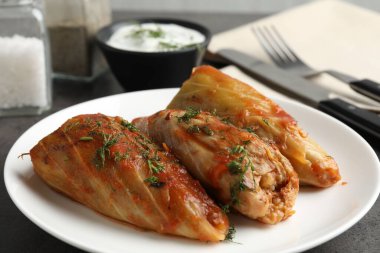 Gri masada servis edilen lezzetli lahana dürümleri, yakın plan.