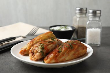 Gri masada servis edilen lezzetli lahana dürümleri, yakın plan.