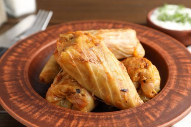 Tahta masada servis edilen lezzetli lahana dürümleri, yakın plan.