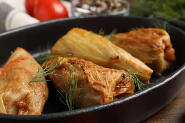 Tahta masada servis edilen lezzetli lahana dürümleri, yakın plan.