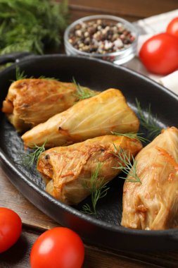 Tahta masada servis edilen lezzetli lahana dürümleri, yakın plan.