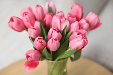 Masadaki vazodaki pembe lale buketi bulanık arka plan, yakın plan